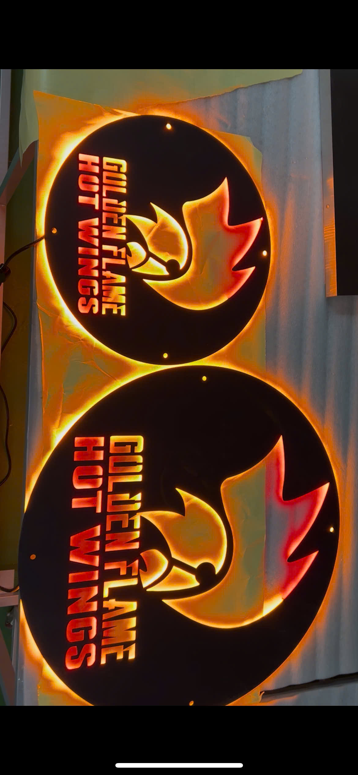 golden flame hot wings metal sign displayed in restaurant and bar